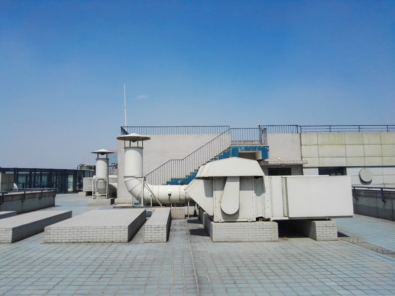 Industrial rooftop HVAC ventilation system with large air ducts and ventilation units installed on a commercial building.