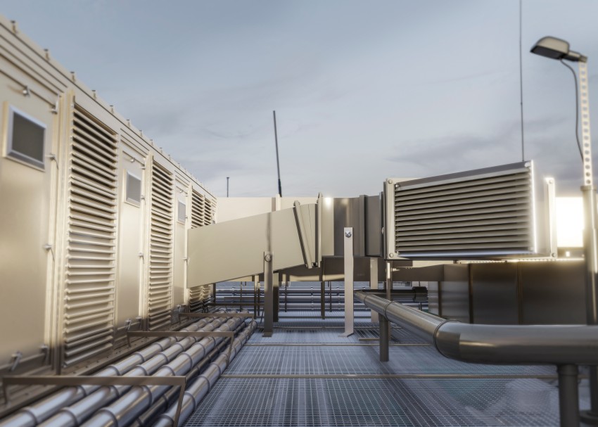 Industrial rooftop HVAC ventilation equipment with large louvered air vents, ducts, pipes, and metal grating.